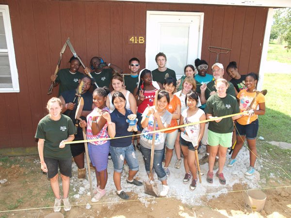 A group of kids smiling, preparing to work