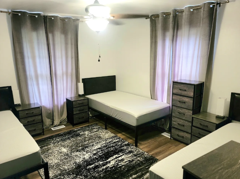 a room with twin beds and drawers